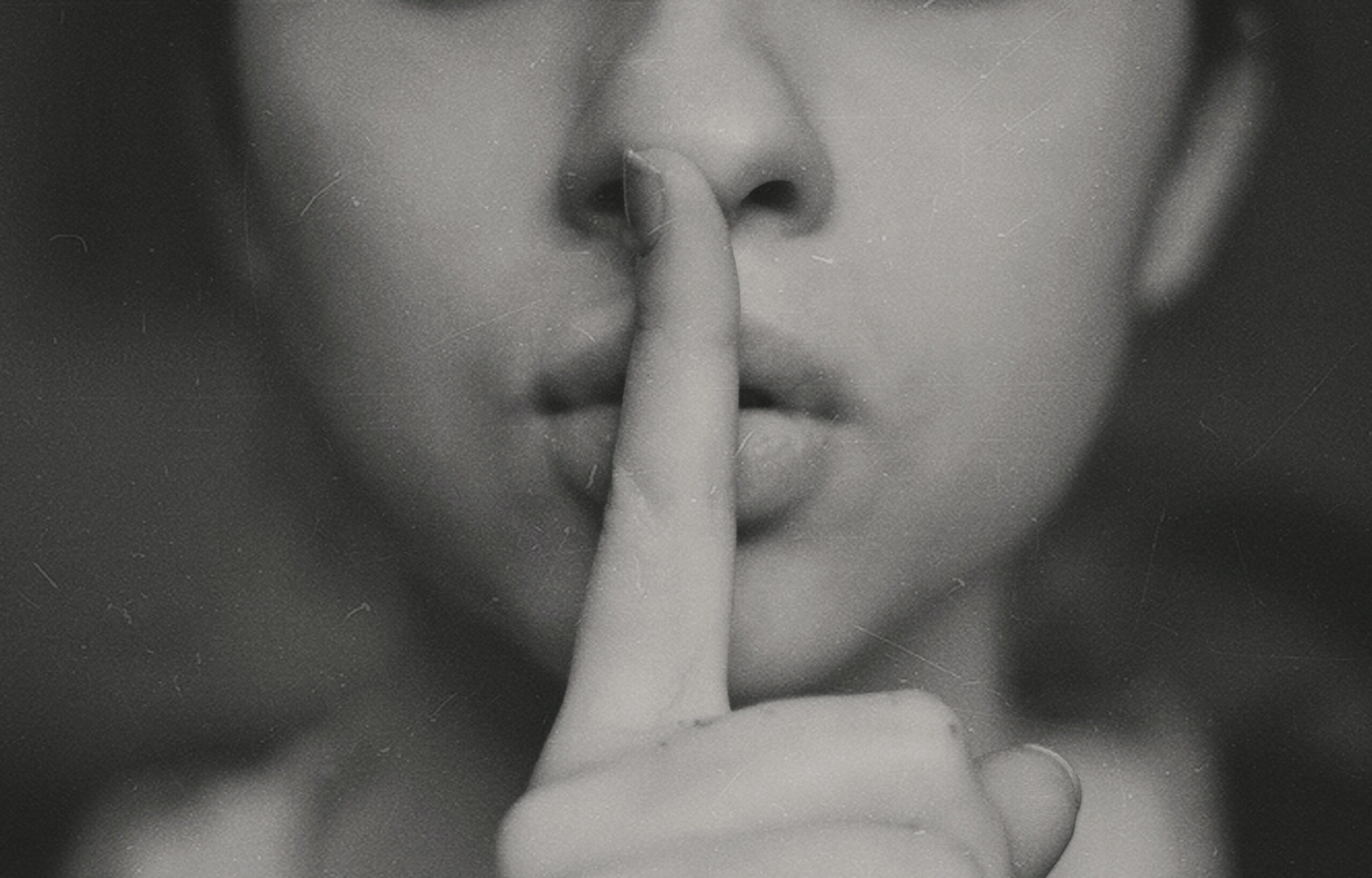 woman pressing finger to lips